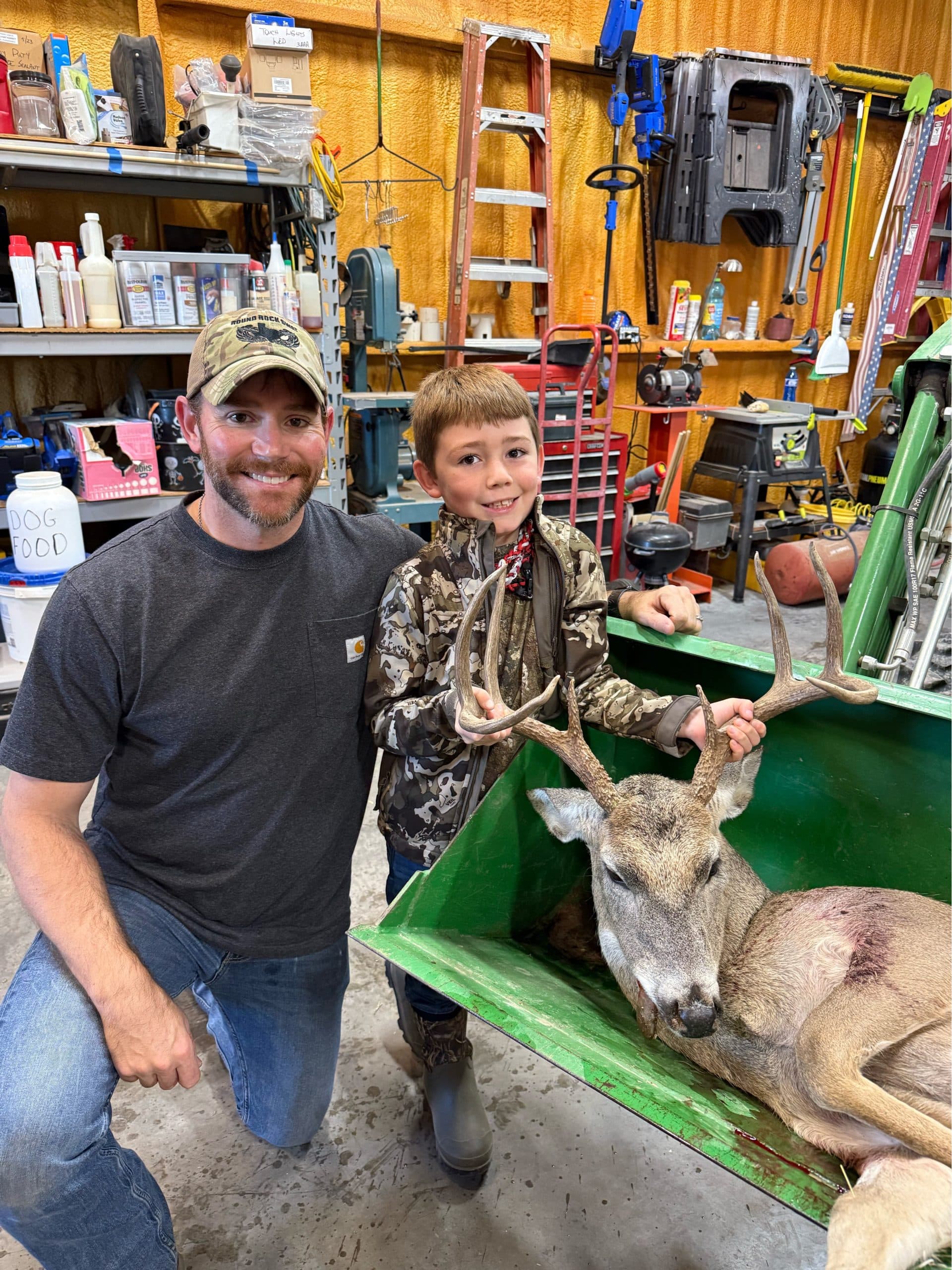 Father and son with a whitetail buck brought in for processing